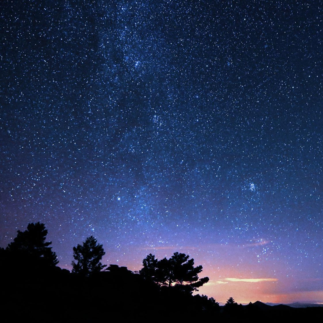 Landscape at night with stars and rising sun