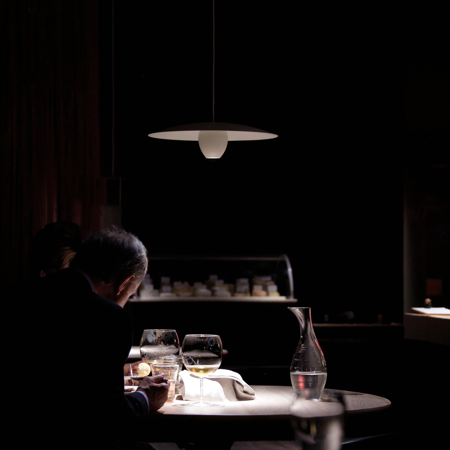 Pendant light over a dining able with glasses of wine